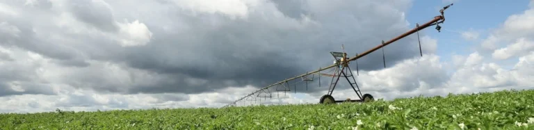 Irrigation system spraying water under cloudy sky