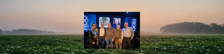 Group posing on stage during recognition event