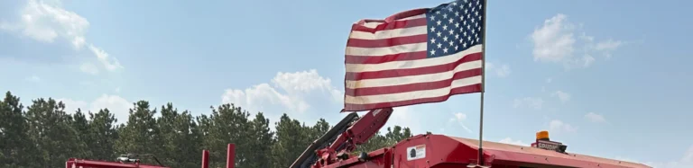American flag waving outdoors above farm equipment