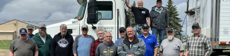 Truck drivers smiling, posing with a truck